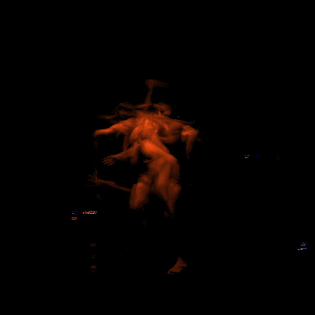 Akad⁰ performing Momentum under warm lighting against a dark stage